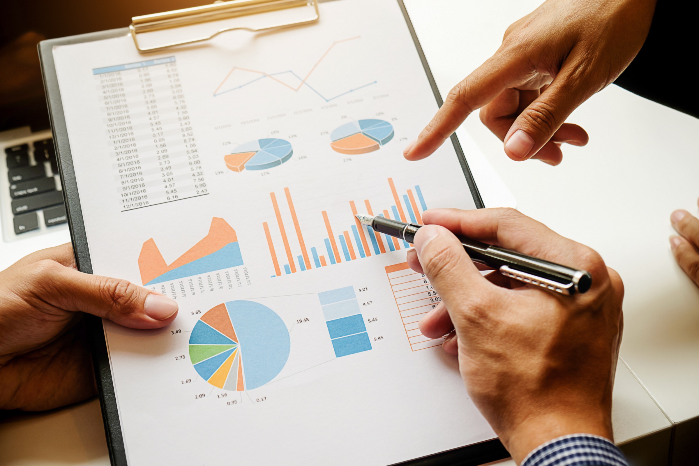 Hands reviewing charts and financial planning documents