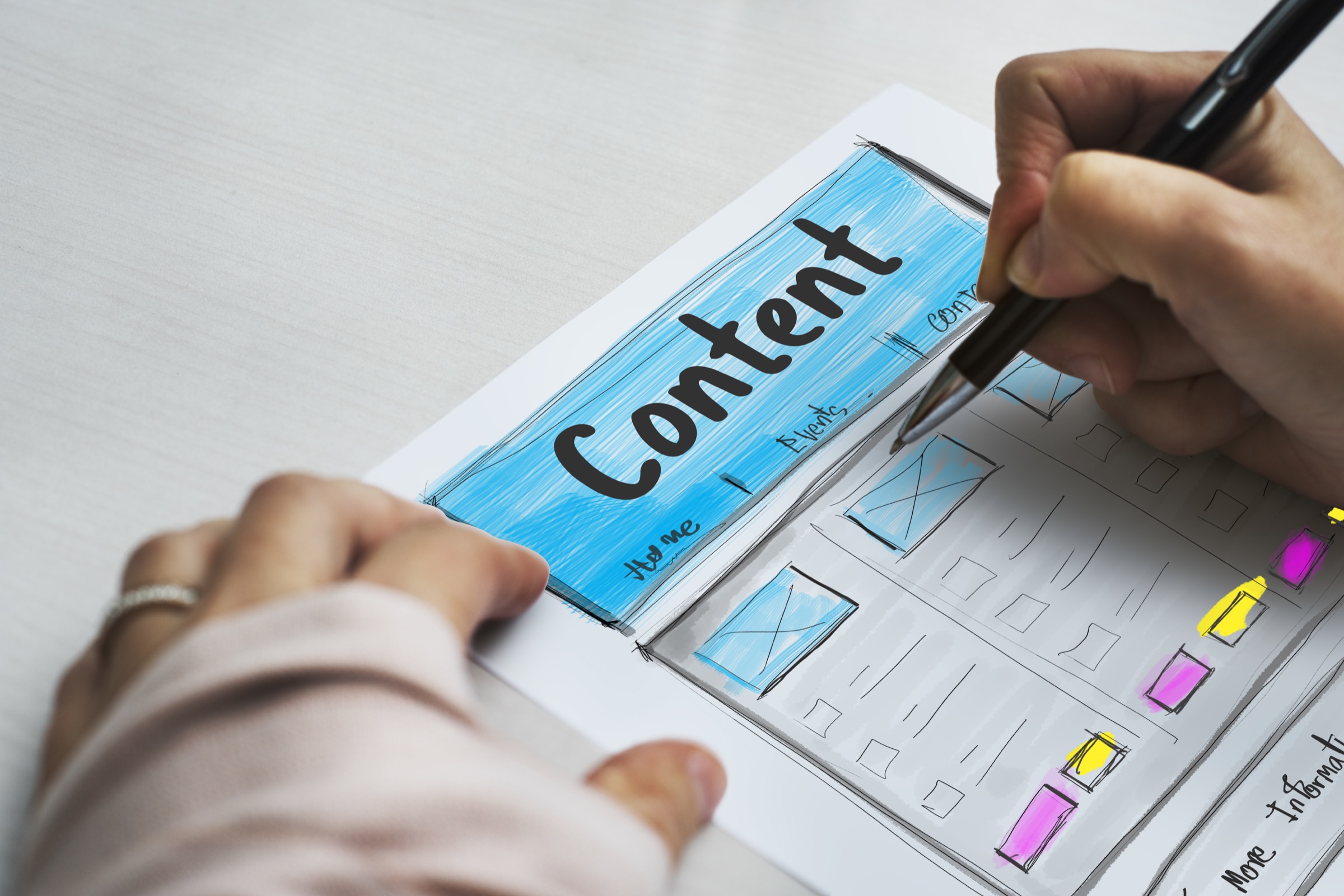 A hand drawing a website content layout